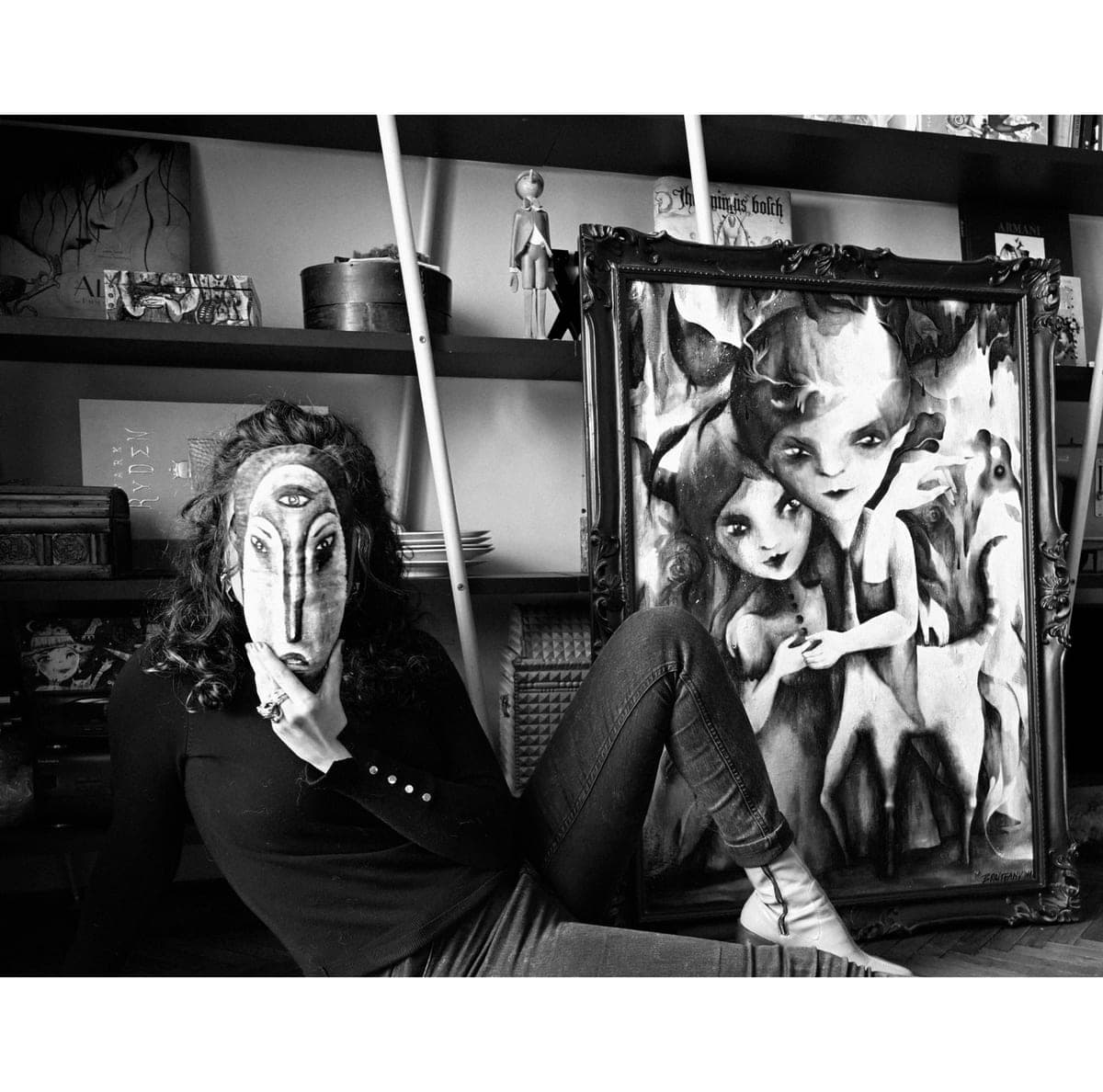 Valentina Brostean in ihrem Atelier in Barcelona, mit einer handbemalten Maske neben einem ihrer gerahmten figurativen Werke