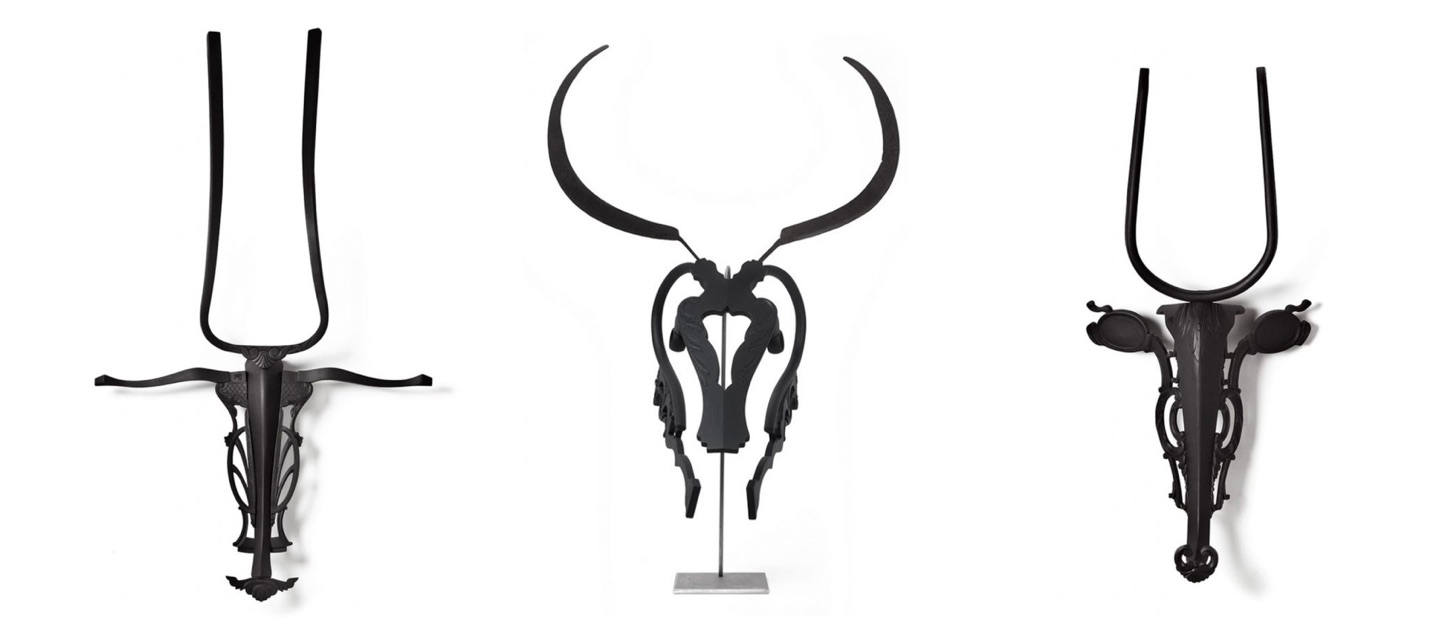 Three of Marc Sparfel's black wall-mounted sculptures assembled from reclaimed furniture parts, evoking horned animal heads